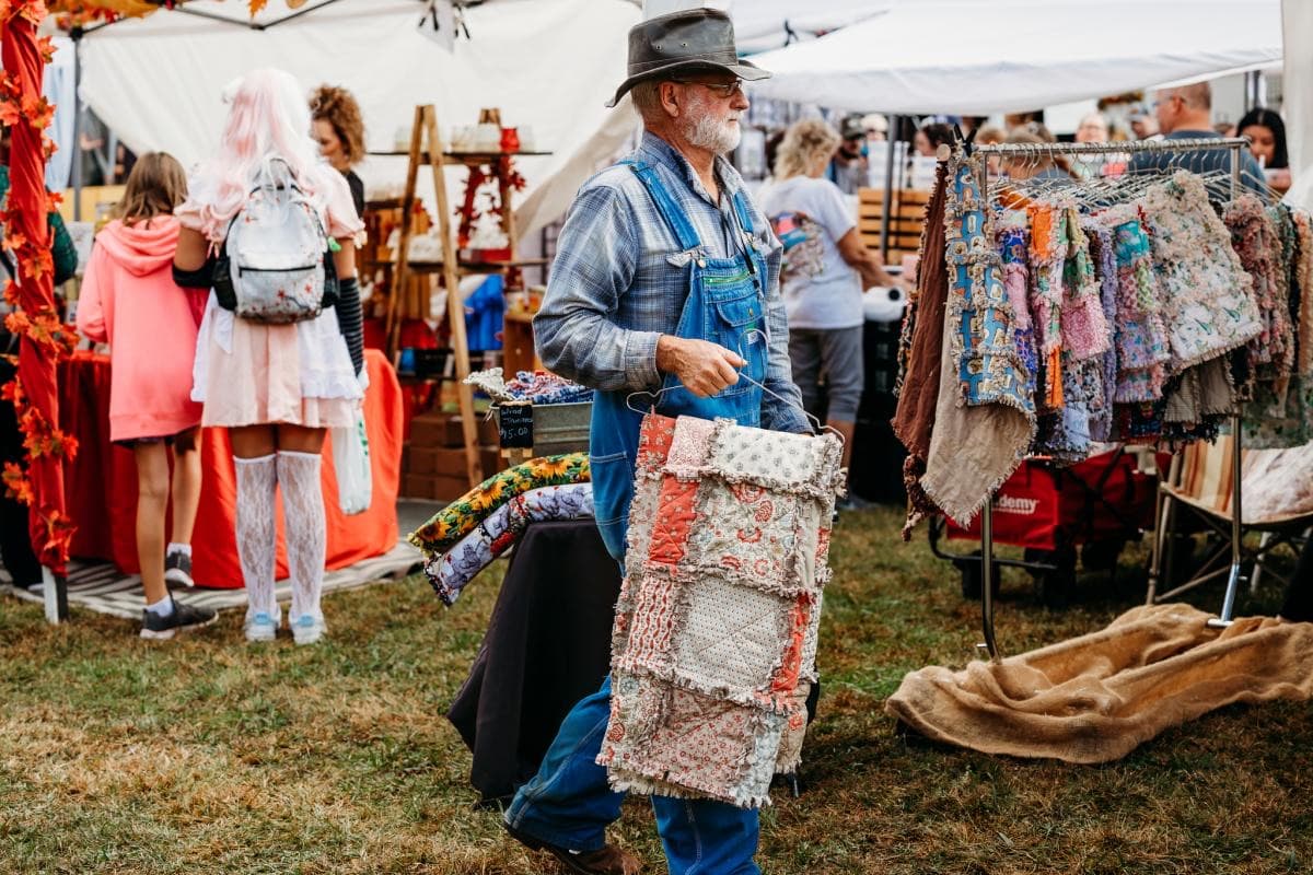 A vendor with handmade quilts at a craft booth